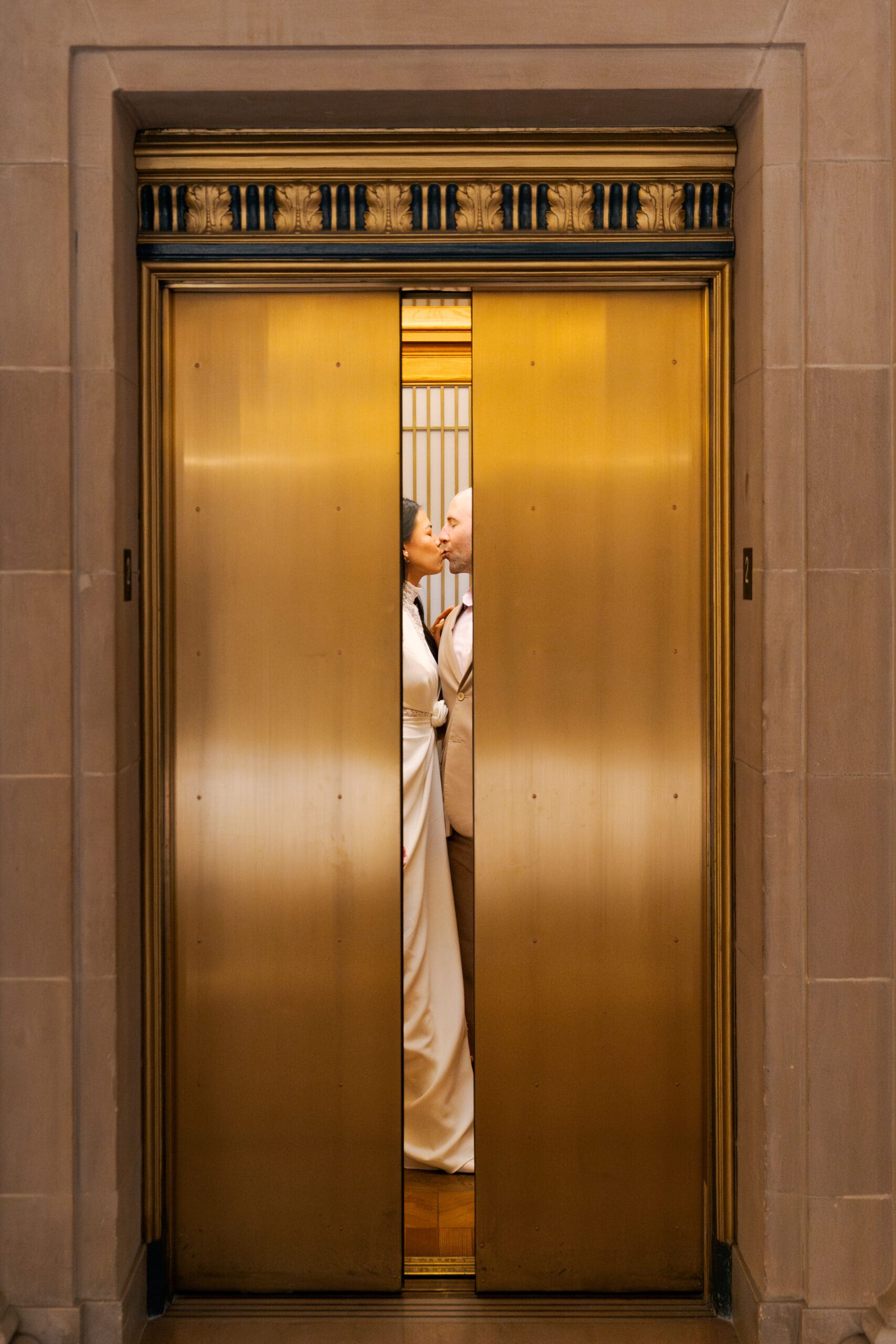 Sneaking in a kiss as the elevator doors close in SF City Hall