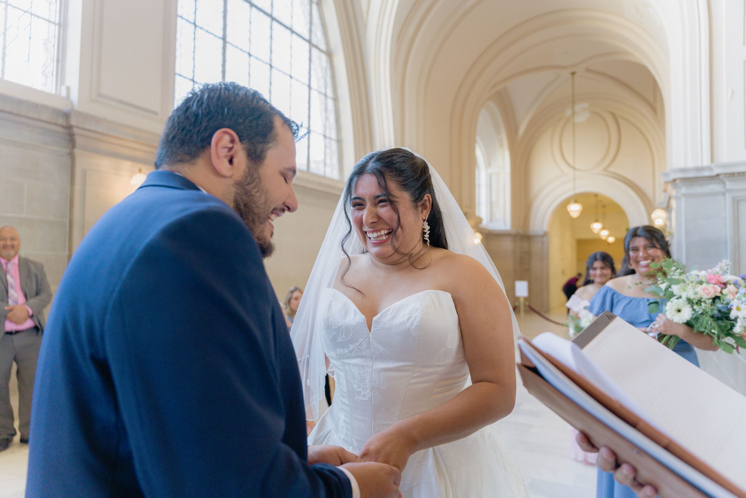 Bride smiles and laughs during the 1 hour reservation ceremony on the 4th floor gallery of San Francisco City Hall