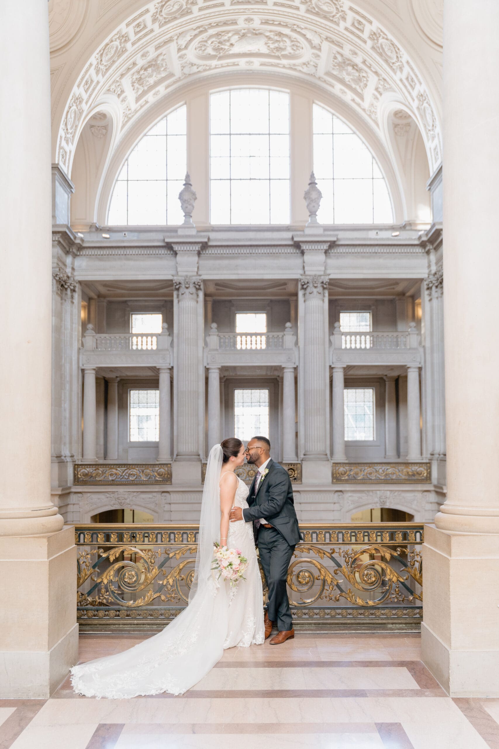 Formal portraits of bride and groom on the second floor of San Francisco City Hall with architecture in the background