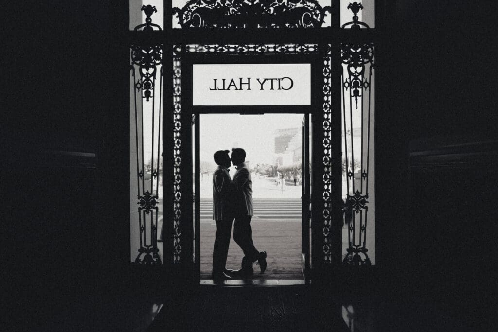 Two grooms share a case as they exit San Francisco City Hall