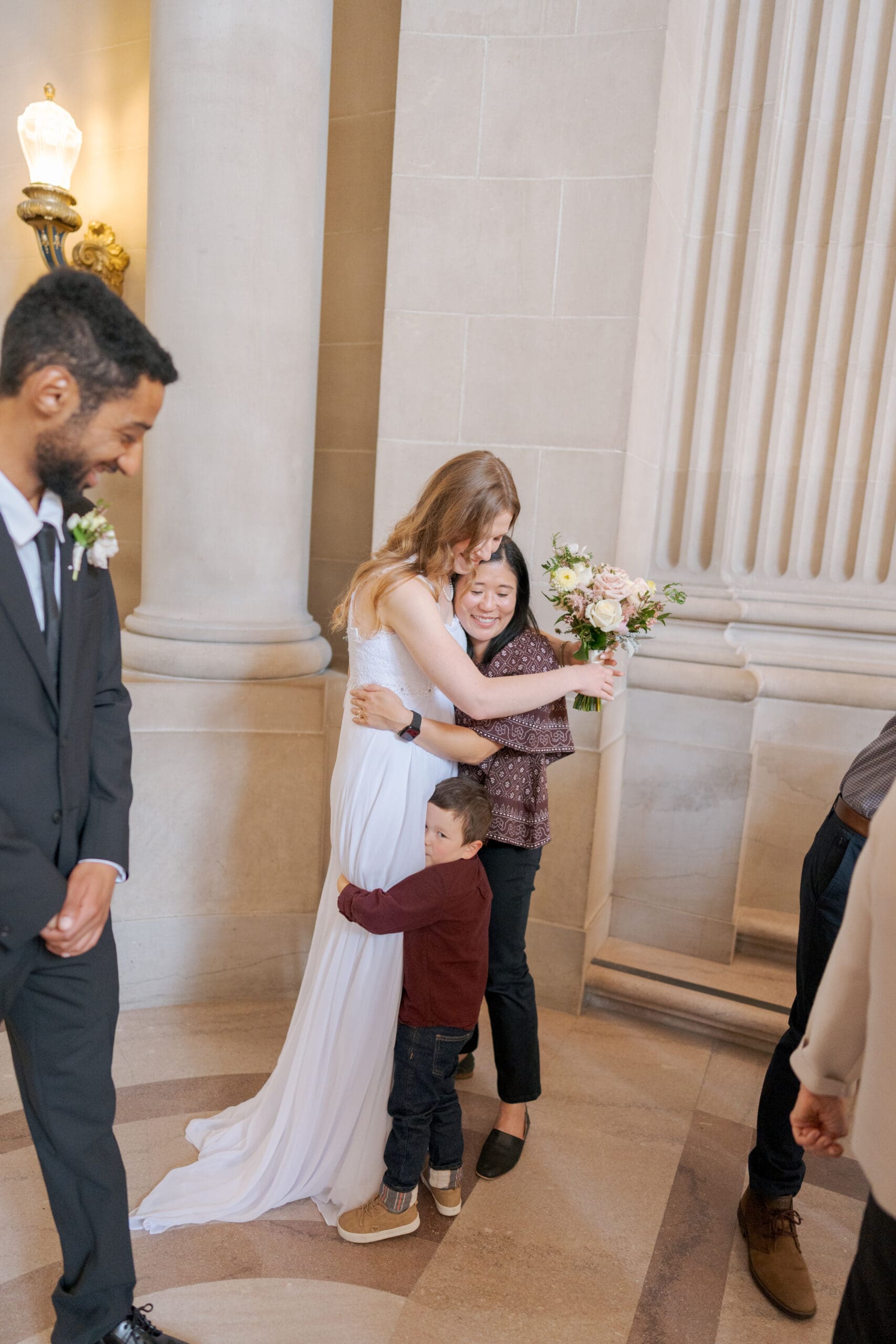 Family members embrace after a surprise at San Francisco City Hall