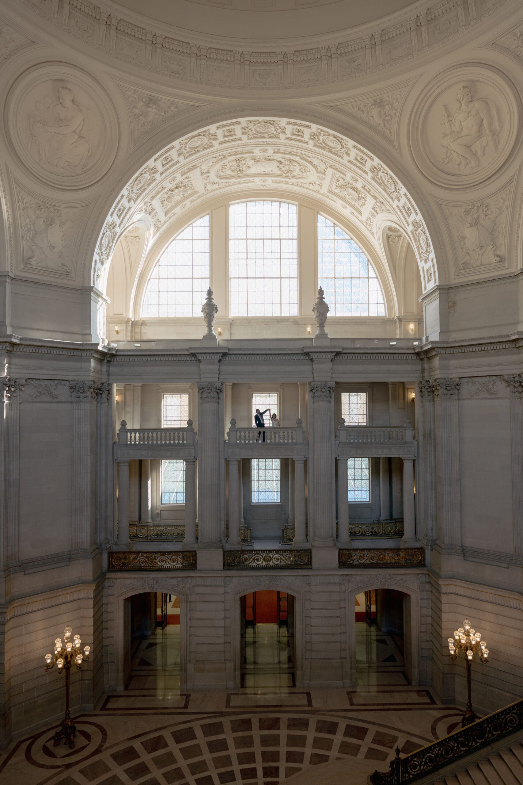 Detail of the gold-leaf railings and limestone arches inside San Francisco City Hall.