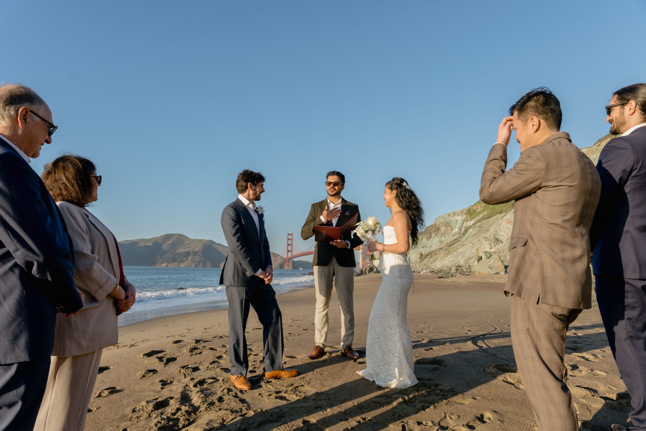 Friends and family gather close to witness the marriage ceremony on Marshall's Beach