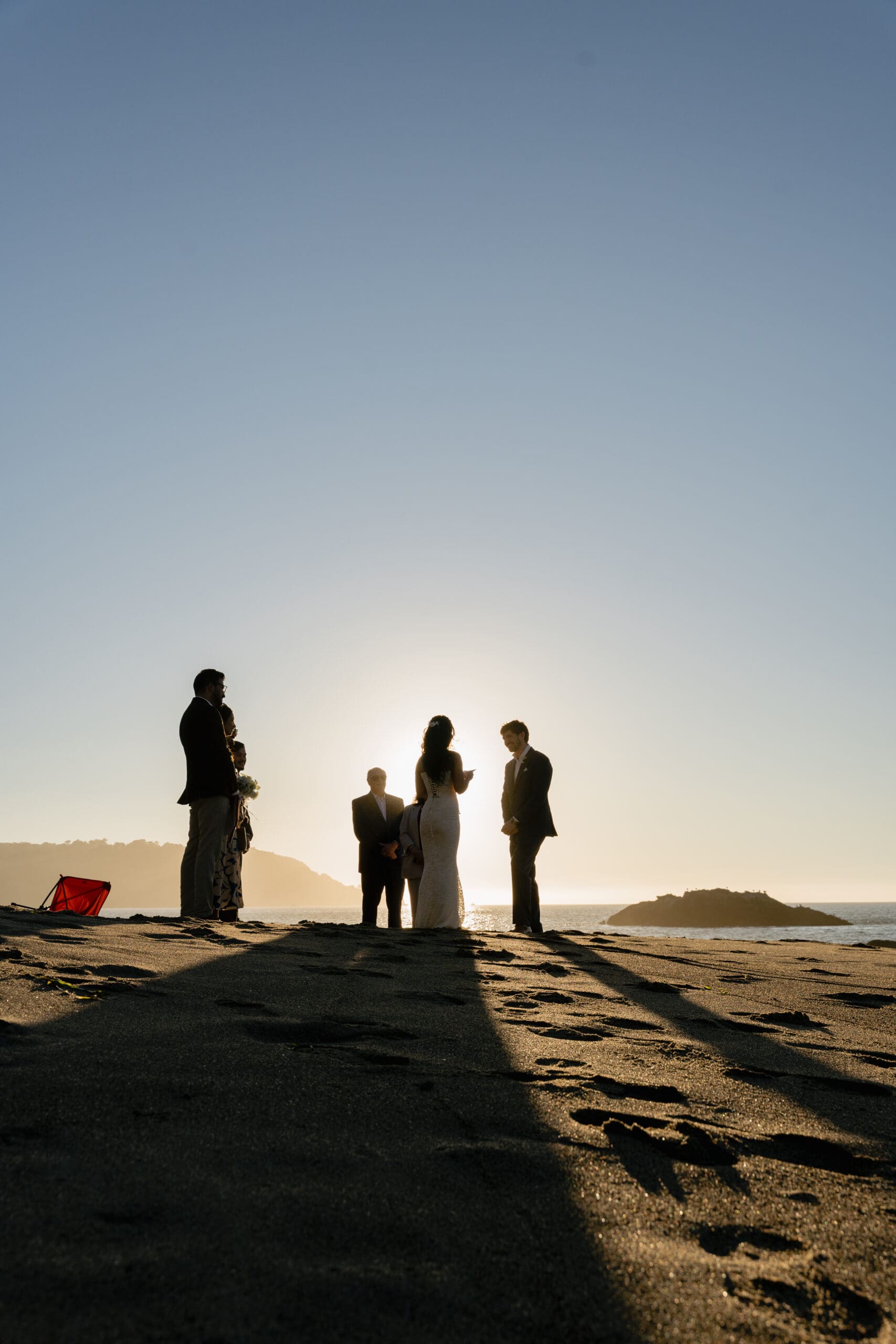 Golden hour light at Marshall's Beach while the bride reads her vows during an elopement ceremony