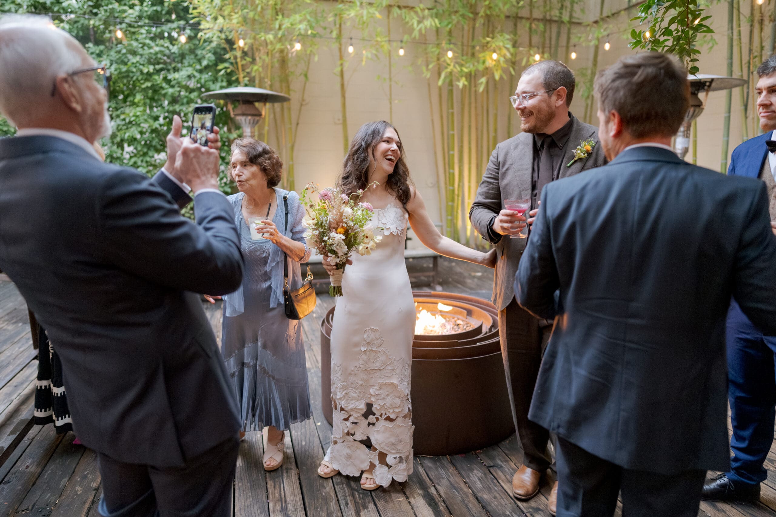 An intimate wedding ceremony setup at Comal Berkeley featuring wooden chairs and lush greenery.