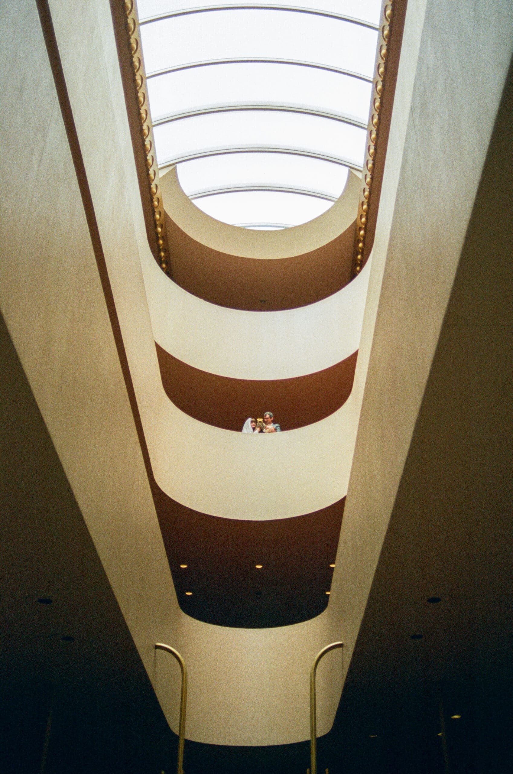 Warn tones of Marin County Civic Center's verticality in wedding portraits captured on film