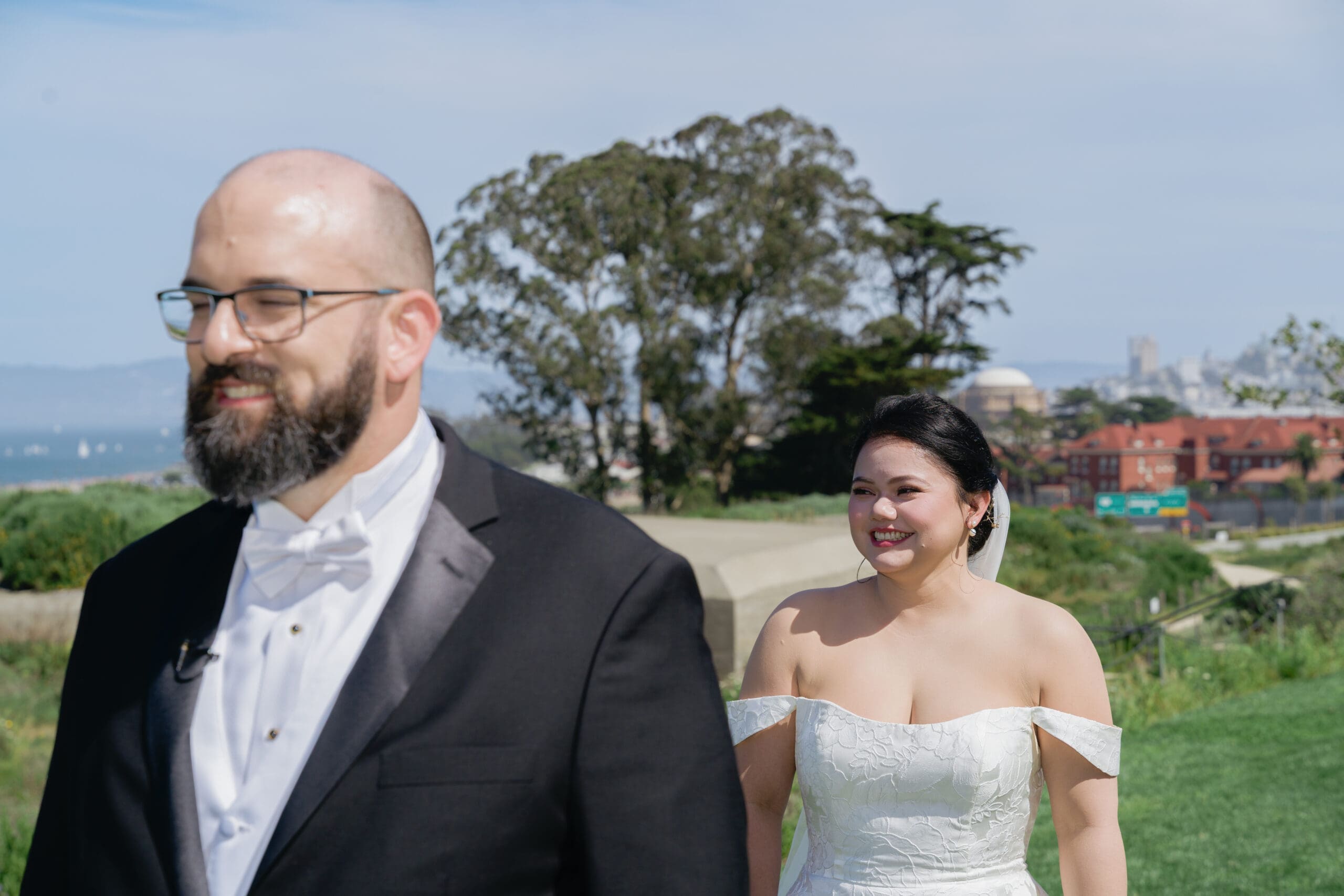 The moment of anticipation before bride and groom do their first look with the San Francisco skyline in the background