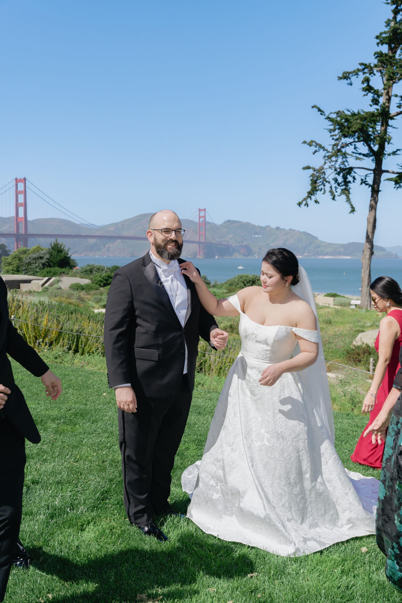 Smiling bride and groom surrounded by family and friends at Battery Bluffs Park
