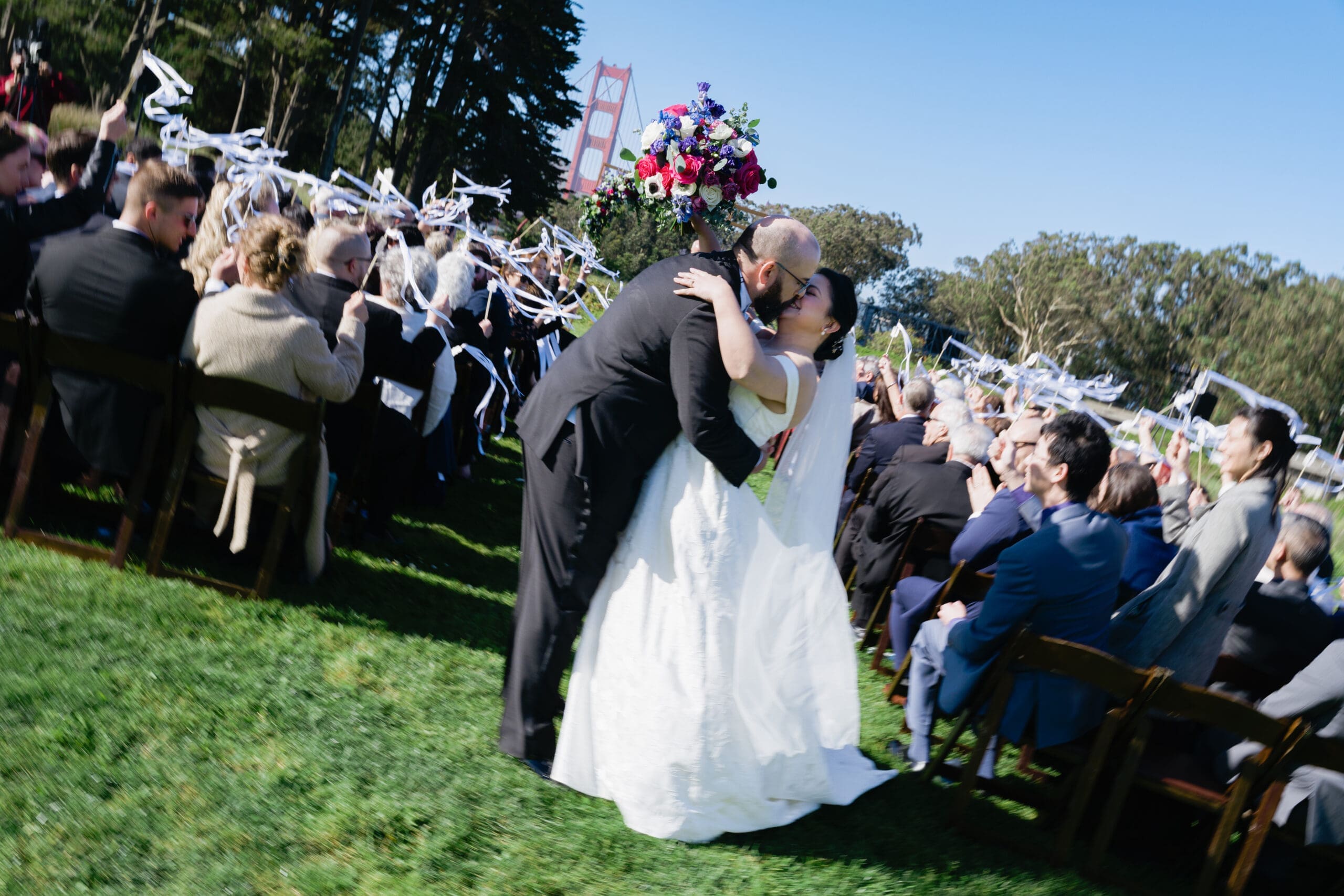 The dip and kiss at the end of the aisle after the outdoor ceremony at the Presidio Log Cabin