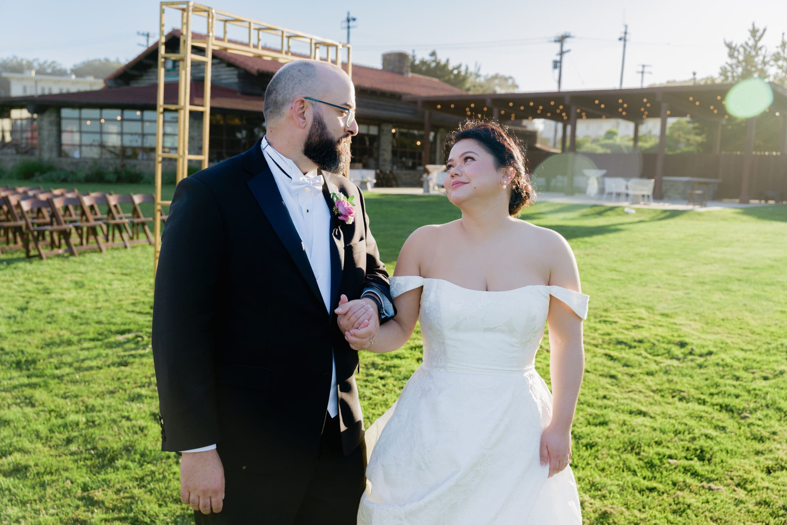 Bride and groom exchange a loving look during golden hour outside of the Log Cabin in the Presidio