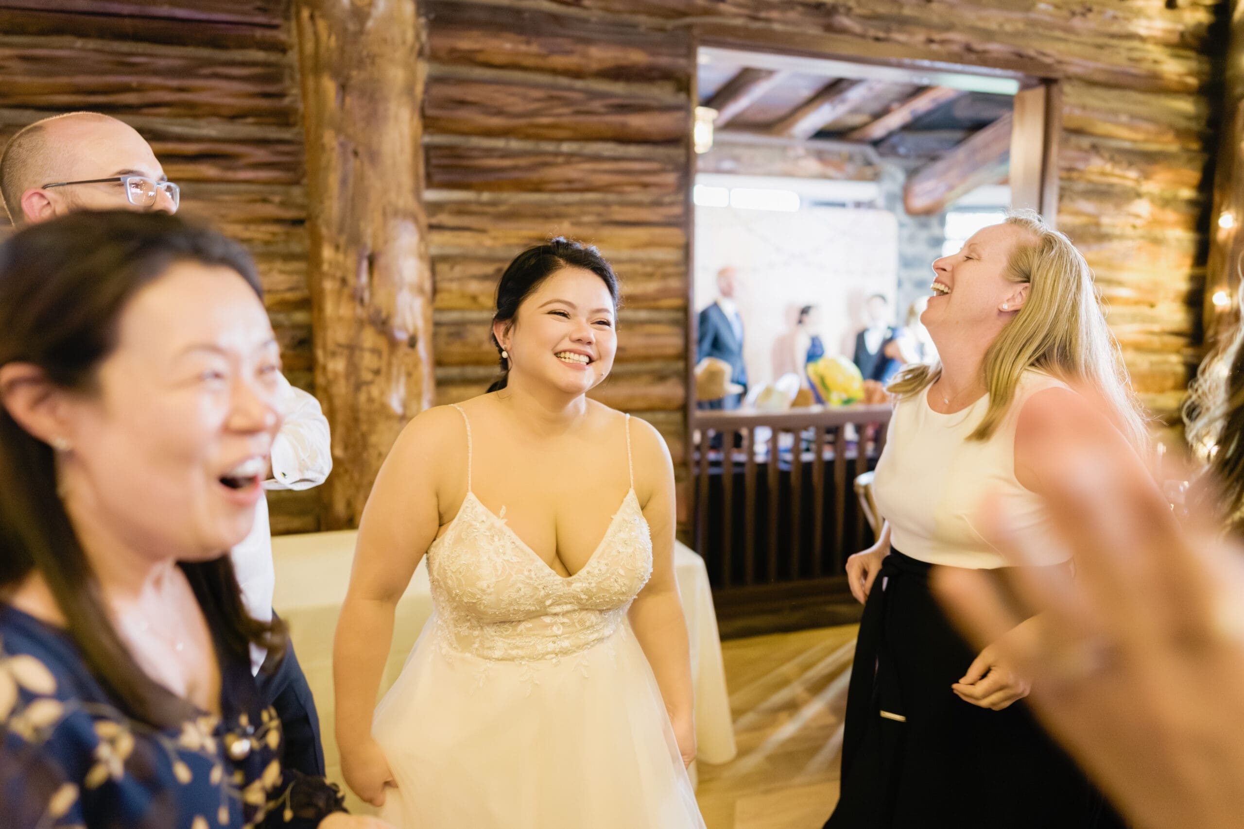 Bride dancing and celebrating with friends on the dancefloor of the Wedgewood Log Cabin