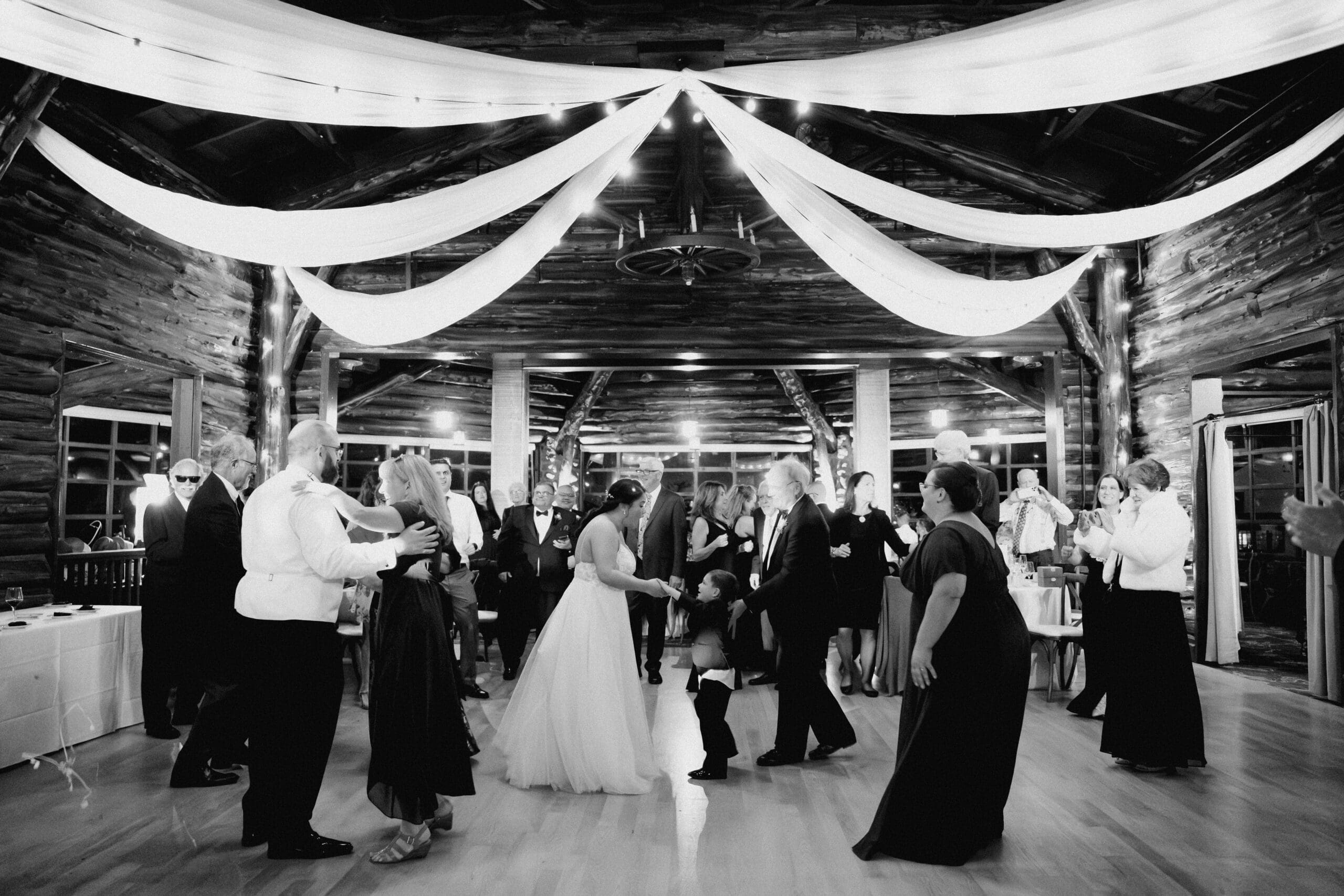 Black and white photo of open dance floor celebrations during a wedding reception at the Presidio Log Cabin