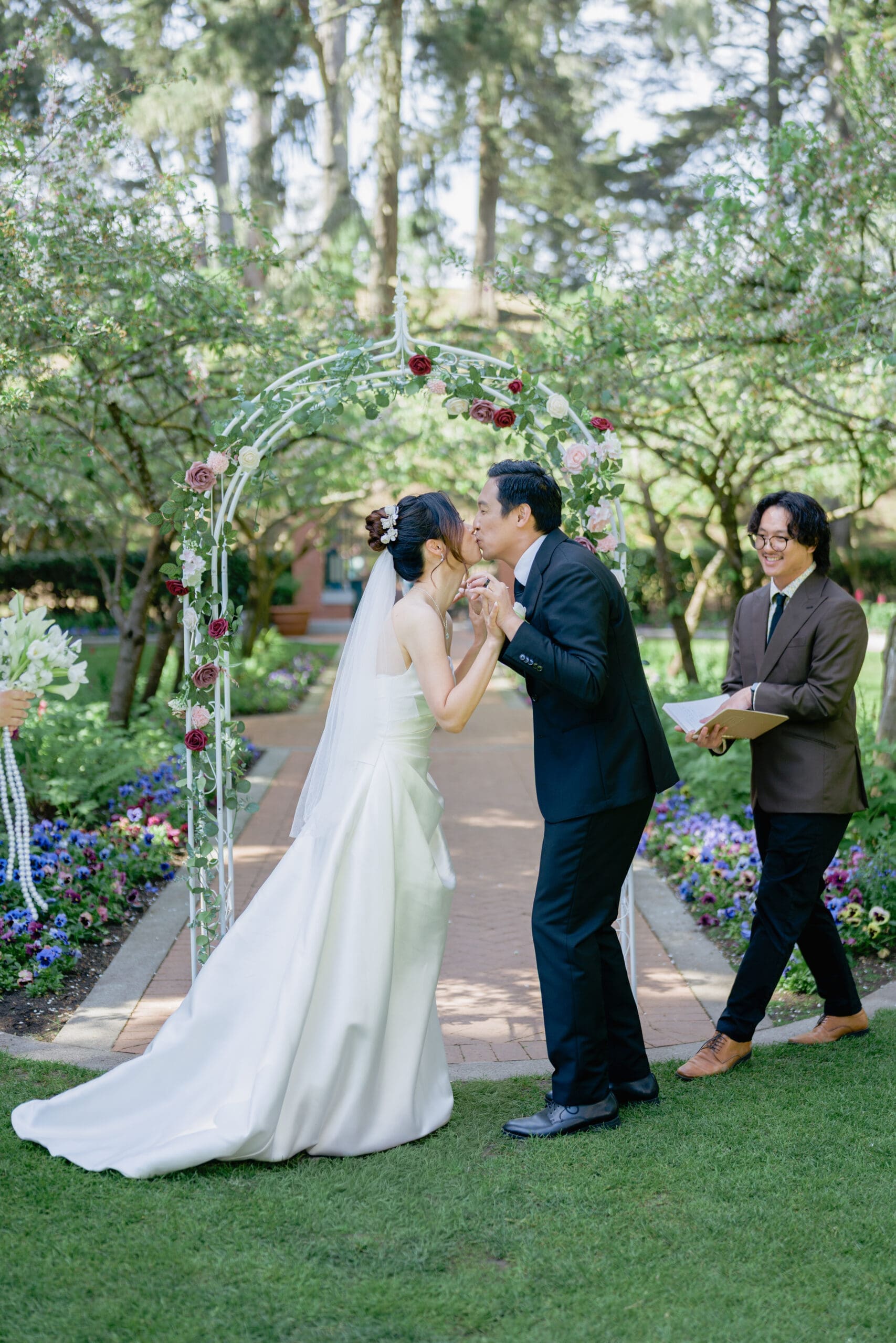 Newlyweds share a first kiss to finish their outdoor ceremony in the Shakespeare Garden
