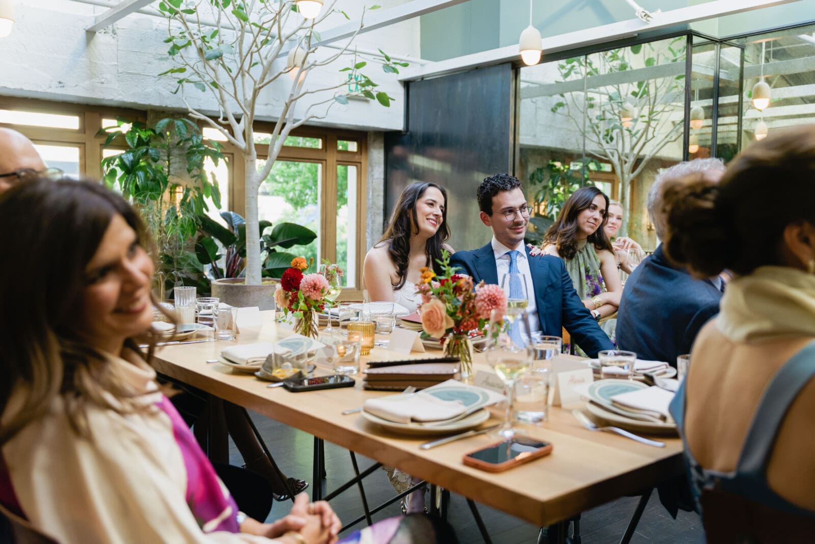 Candid dinner conversation at a long table micro wedding reception at The Progress SF