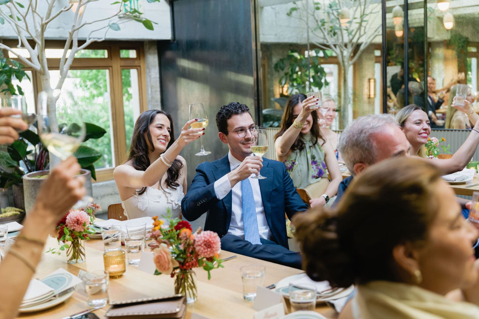 Reaction shot of bride and groom listening to toasts during a private dinner at The Progress