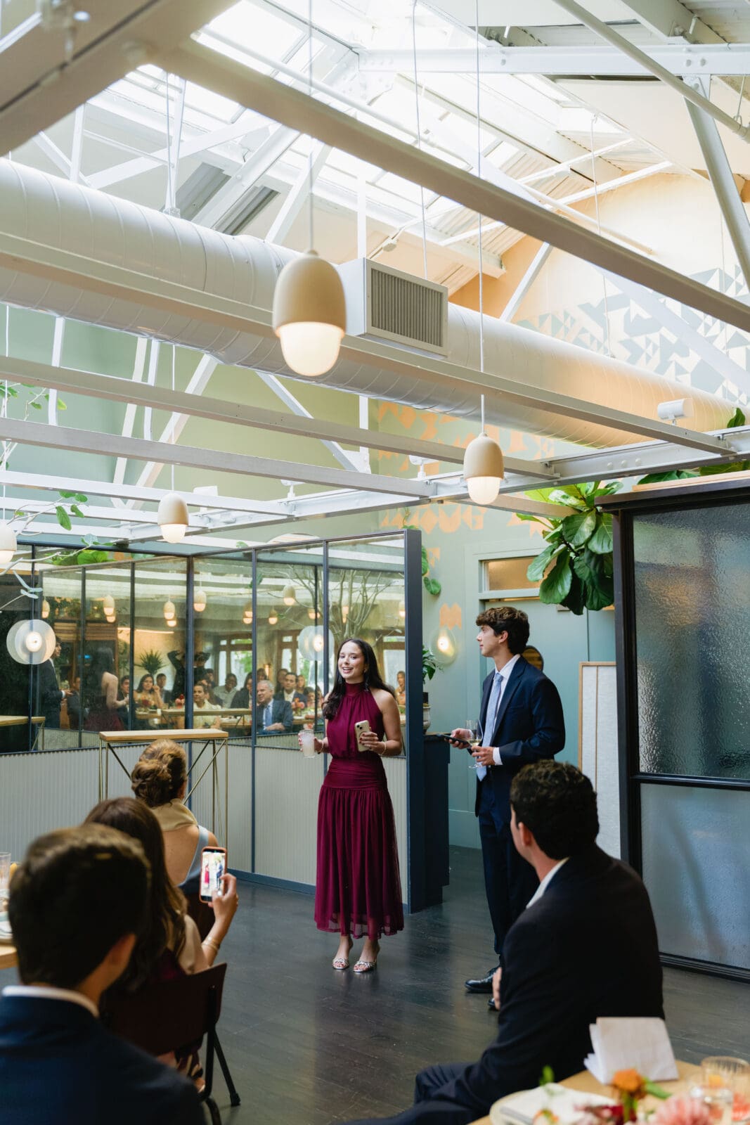 Wedding guests raising glasses in a toast during dinner at The Progress SF